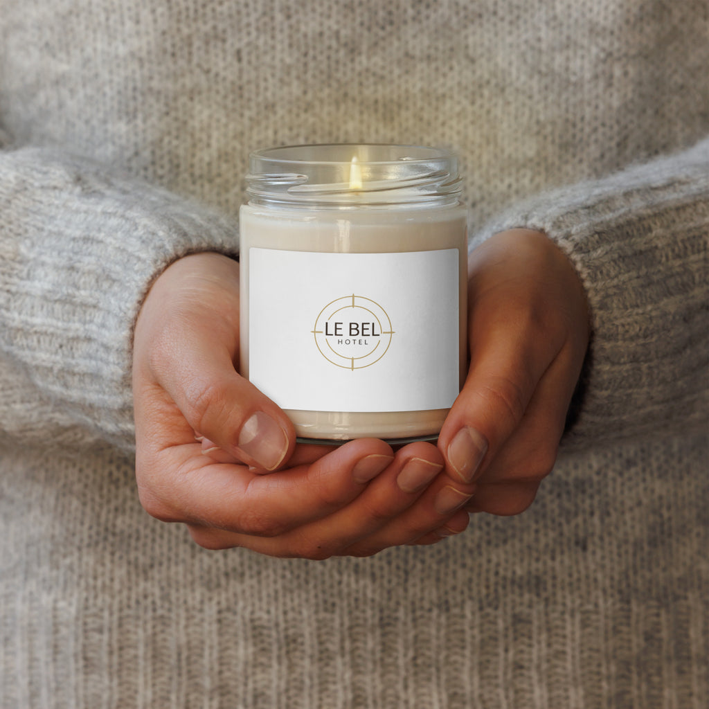 Person holding the Le Bell hand-poured soy candle in a glass jar against a clean aesthetic background.